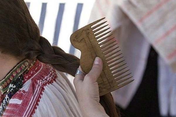 славянская девушка расчесывает волосы гребнем