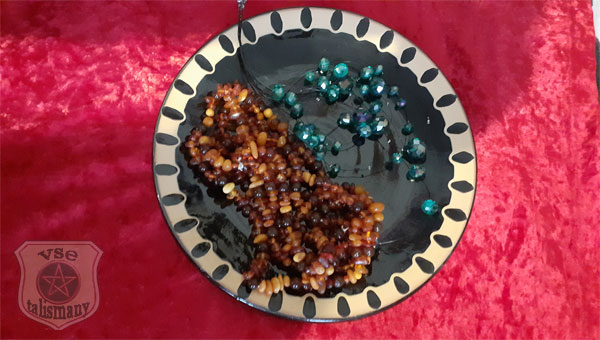 керамическое блюдце, янтарные бусы и красный шелк