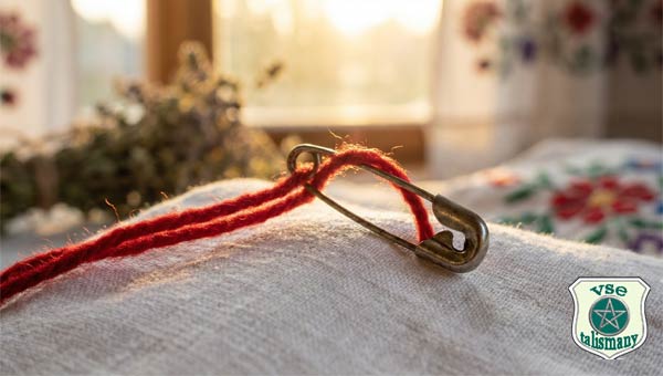 красная нить, продетая в булавку